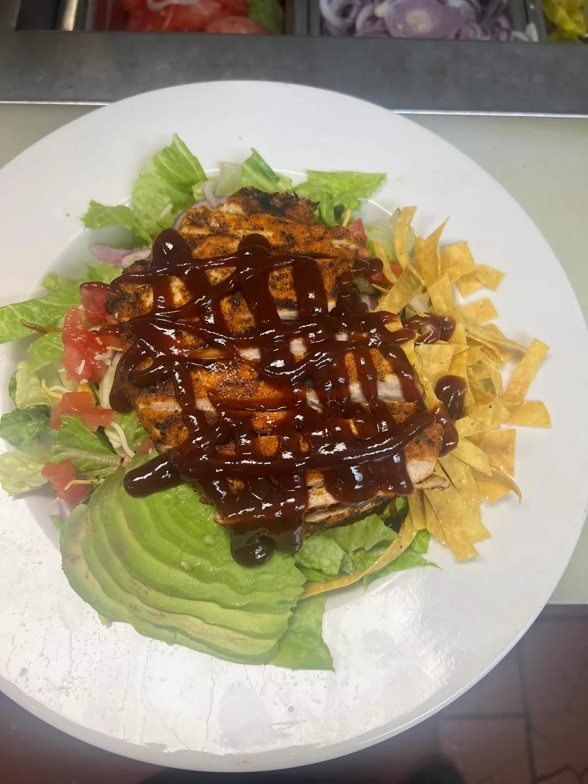 Before: grilled chicken salad photographed under flat kitchen lighting with prep counter background