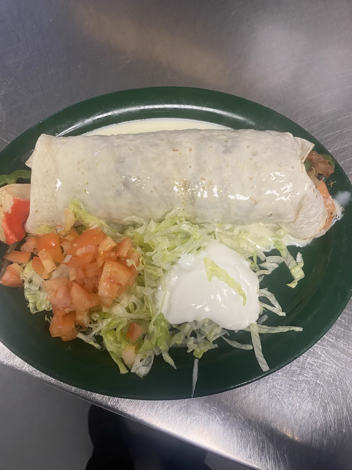 Before: burrito on green plate with washed-out lighting and cluttered prep area